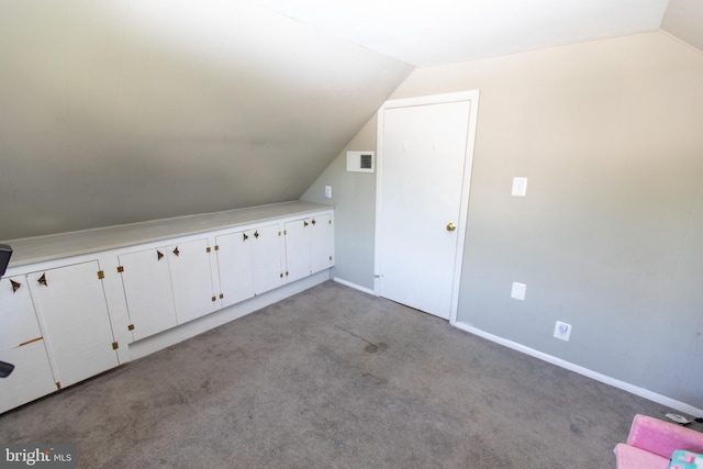 additional living space featuring light colored carpet and vaulted ceiling