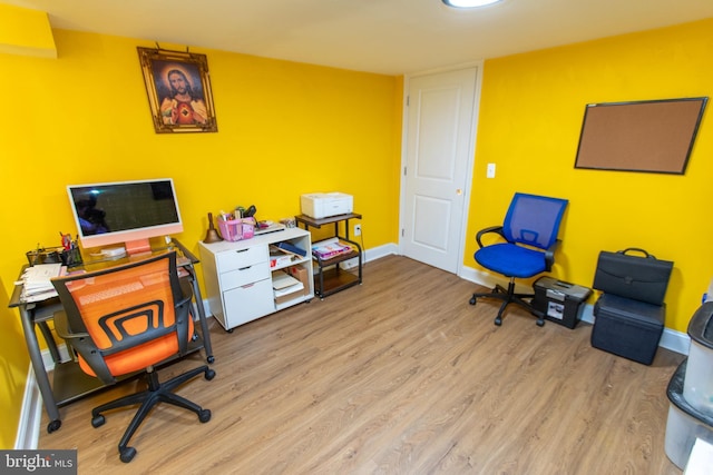 home office with light hardwood / wood-style flooring