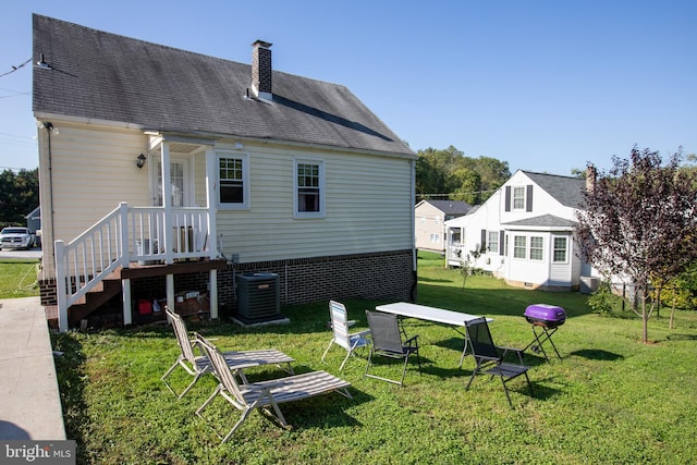 back of house featuring a yard and central air condition unit