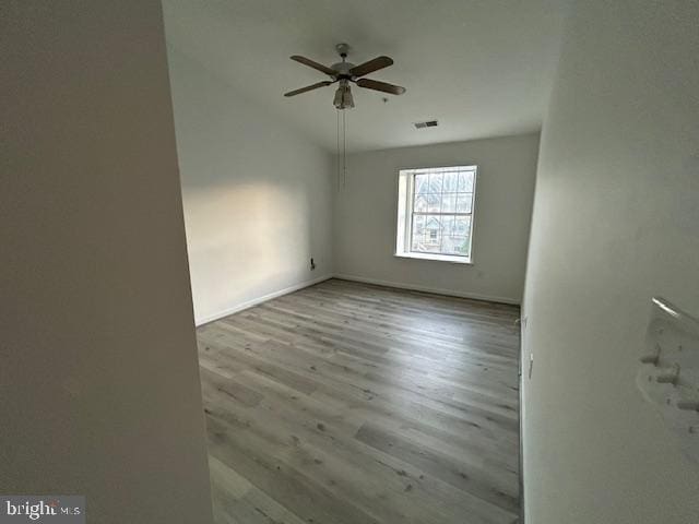 spare room with lofted ceiling, light hardwood / wood-style flooring, and ceiling fan