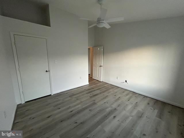 unfurnished bedroom featuring hardwood / wood-style flooring, ceiling fan, and high vaulted ceiling