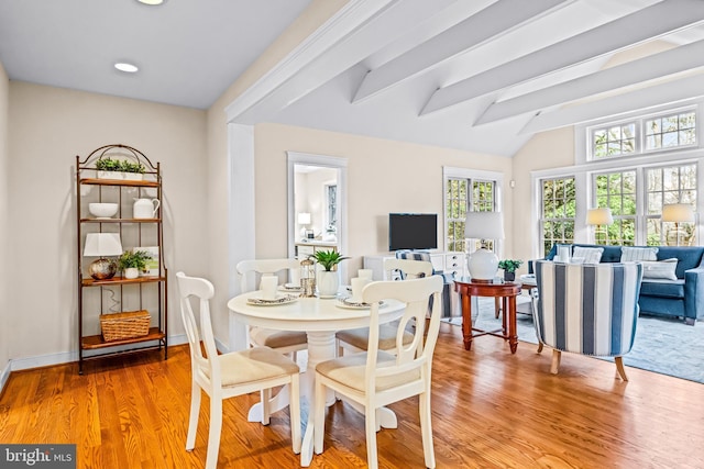 dining space featuring vaulted ceiling with beams and light wood-type flooring