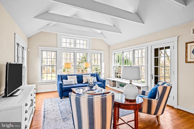 sunroom featuring vaulted ceiling with beams