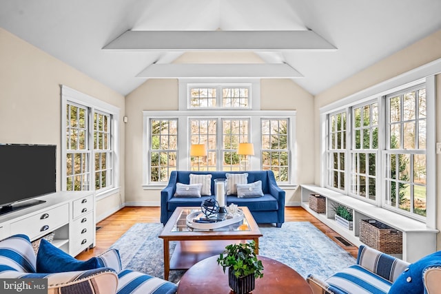 sunroom / solarium featuring lofted ceiling with beams and a wealth of natural light