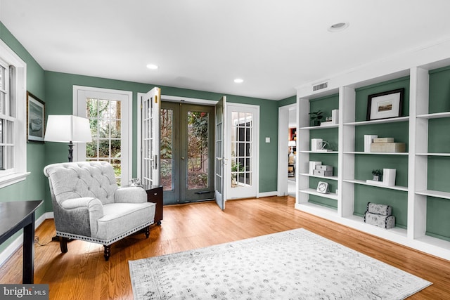 living area with hardwood / wood-style flooring and french doors