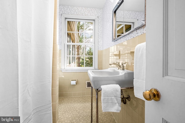 bathroom featuring sink and tile walls