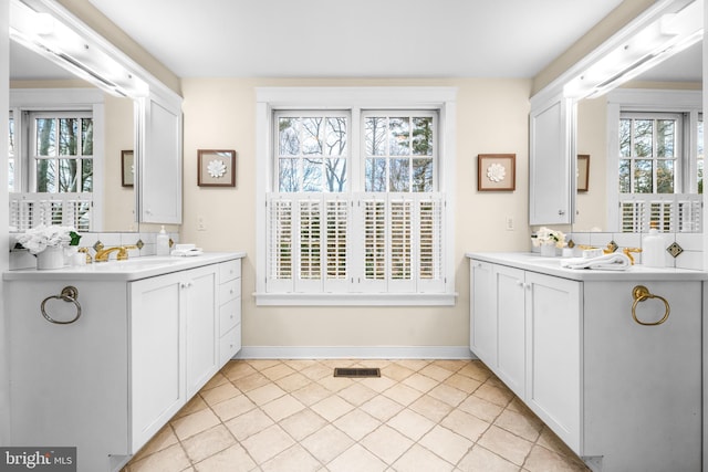 bathroom with backsplash, vanity, and a wealth of natural light