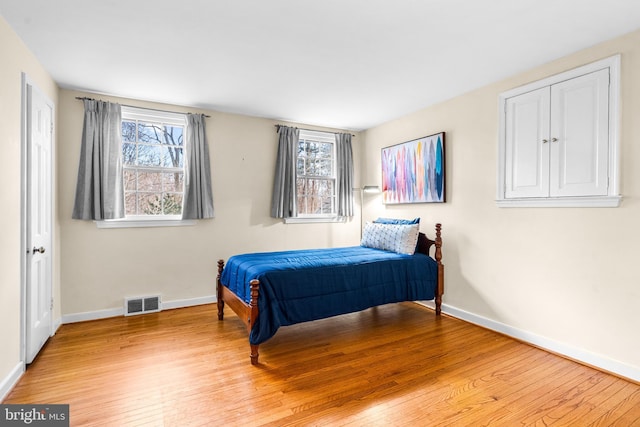 bedroom with multiple windows and light hardwood / wood-style floors