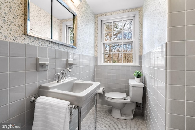 bathroom with tile walls, tile patterned floors, and toilet