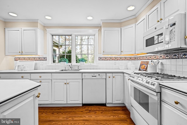 kitchen featuring white cabinetry, sink, white appliances, and backsplash