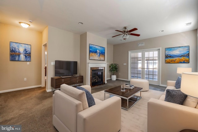 carpeted living room featuring ceiling fan, a high end fireplace, and french doors