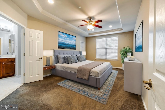 bedroom with a raised ceiling, ceiling fan, and dark carpet