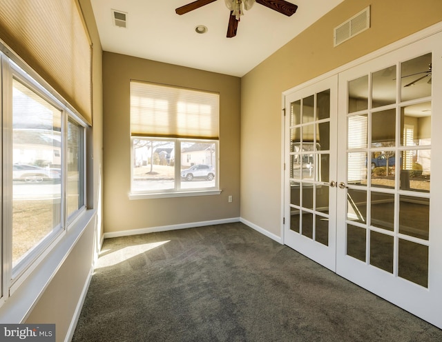 spare room featuring french doors, ceiling fan, and dark carpet