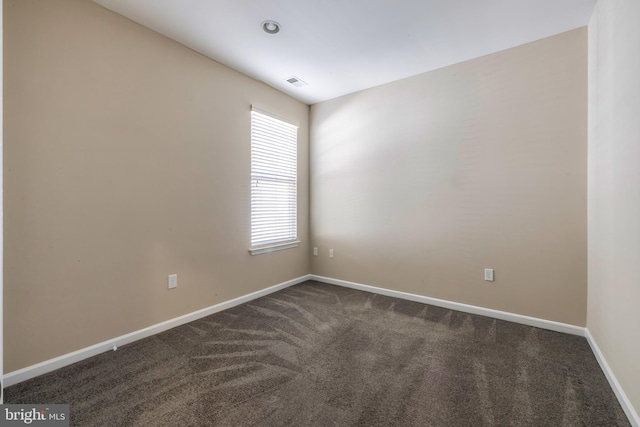 empty room with dark colored carpet