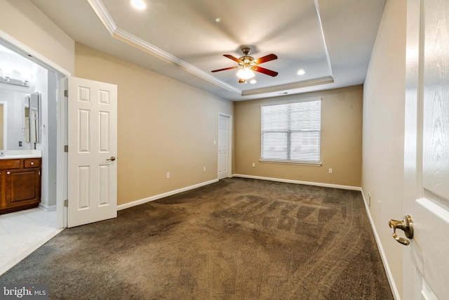 carpeted empty room with ornamental molding, a raised ceiling, and ceiling fan