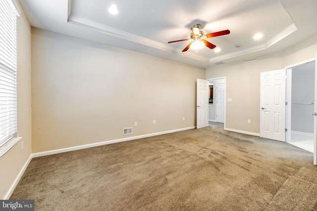 unfurnished bedroom featuring ceiling fan, ornamental molding, carpet flooring, and a raised ceiling