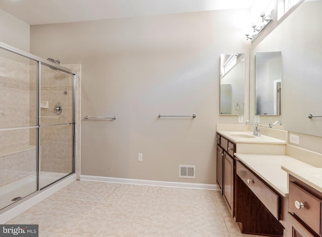 bathroom featuring tile patterned flooring, vanity, and walk in shower