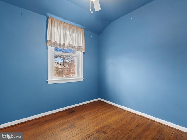 spare room featuring ceiling fan, baseboards, vaulted ceiling, and hardwood / wood-style floors