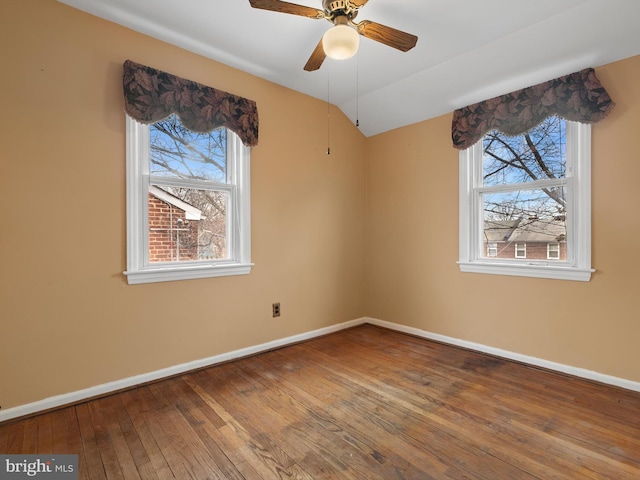 empty room with hardwood / wood-style floors, a ceiling fan, baseboards, and a wealth of natural light