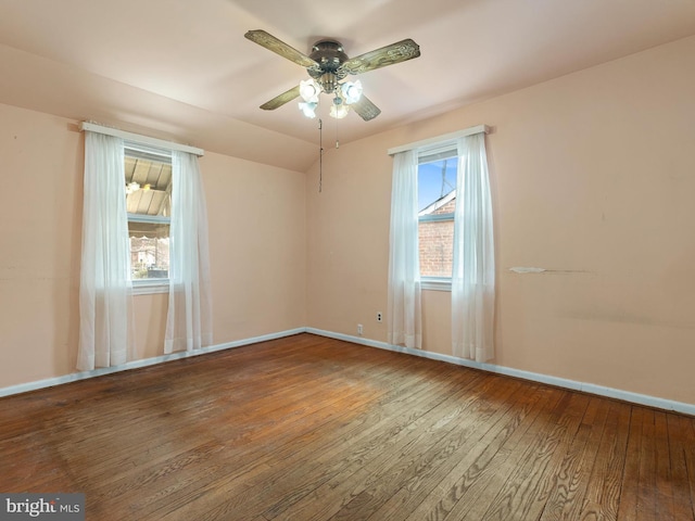 unfurnished room featuring lofted ceiling, hardwood / wood-style flooring, baseboards, and a ceiling fan