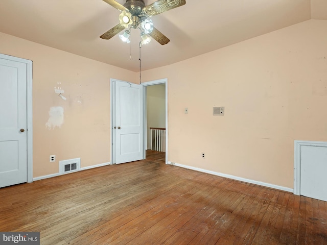 empty room featuring a ceiling fan, wood-type flooring, visible vents, and baseboards