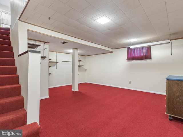 finished basement with carpet floors, stairway, visible vents, and baseboards