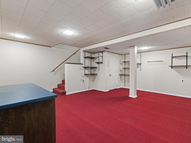 finished basement with stairs, baseboards, and carpet flooring