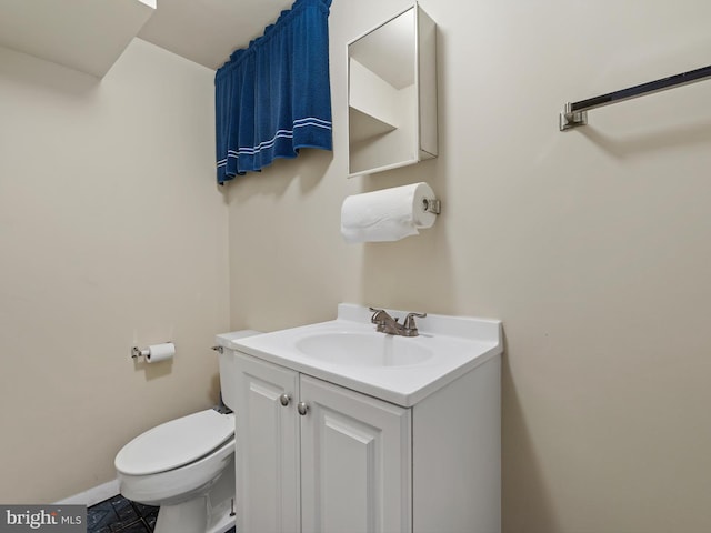 bathroom featuring toilet, baseboards, and vanity