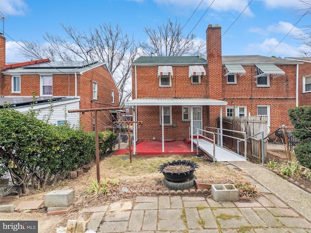 back of property featuring brick siding and fence