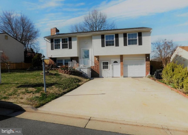 raised ranch with a garage and a front lawn