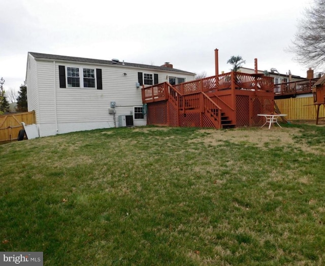 rear view of house with a yard and a deck