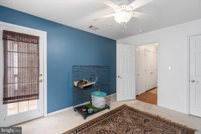 interior space featuring light colored carpet and ceiling fan