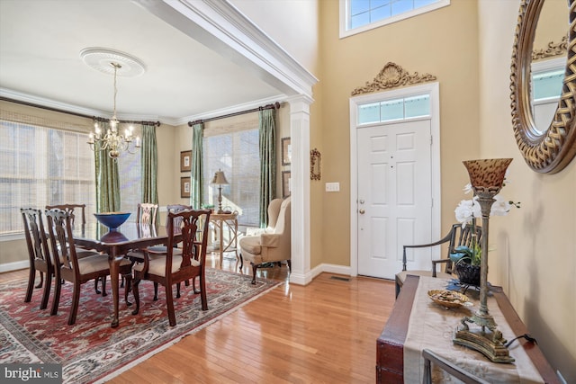 dining area featuring ornamental molding, hardwood / wood-style floors, and a notable chandelier