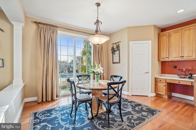 dining room with a wealth of natural light, built in desk, and ornate columns