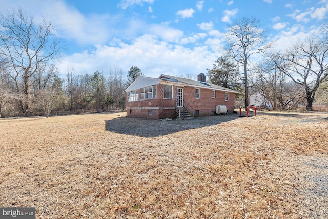 view of property exterior featuring brick siding and a chimney