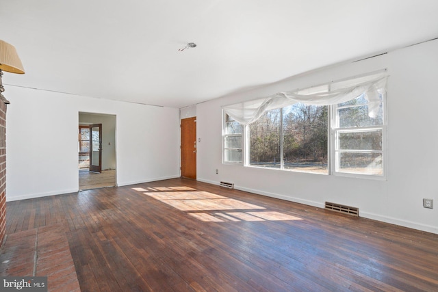 unfurnished living room with baseboards, visible vents, and dark wood-type flooring