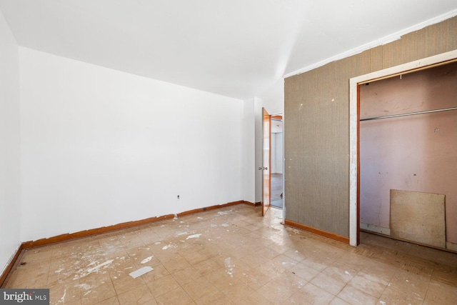 unfurnished bedroom with a closet and baseboards