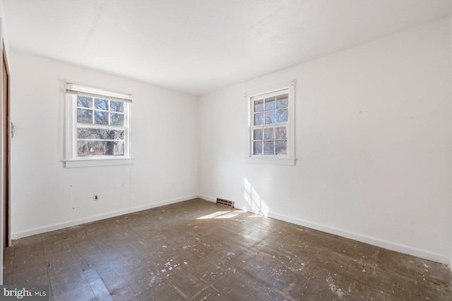 spare room with plenty of natural light and baseboards