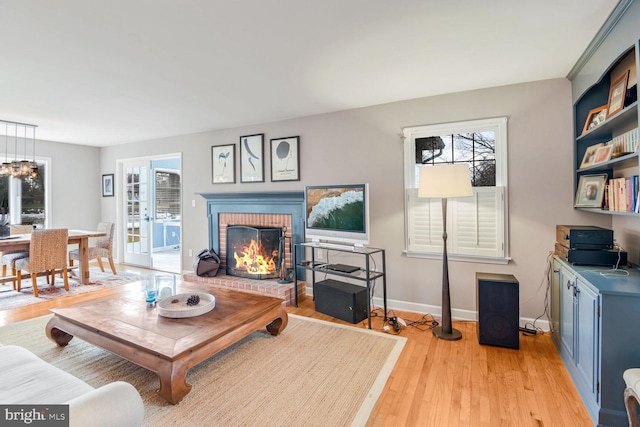 living room with light wood-type flooring and a fireplace