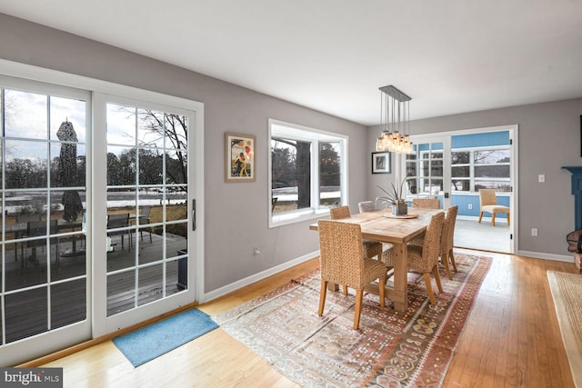 dining area featuring an inviting chandelier, a wealth of natural light, and light wood-type flooring