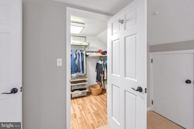 walk in closet featuring vaulted ceiling and hardwood / wood-style floors