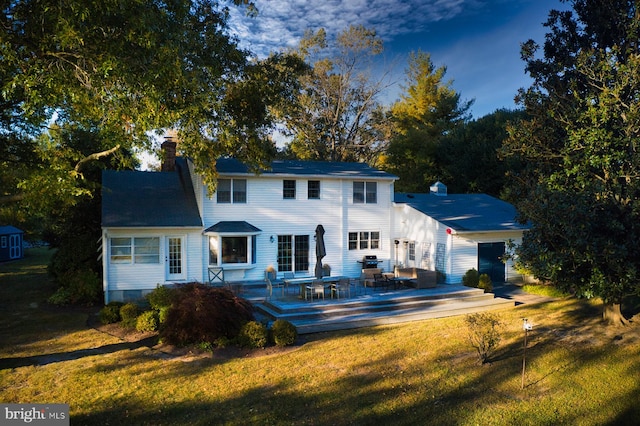 view of front facade with a deck and a front lawn