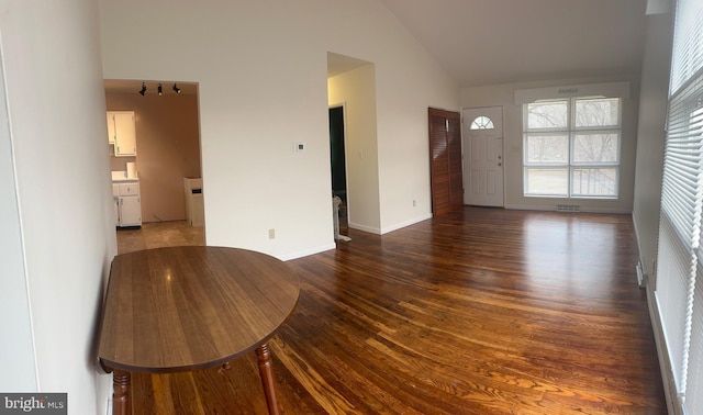 unfurnished living room featuring wood-type flooring and high vaulted ceiling