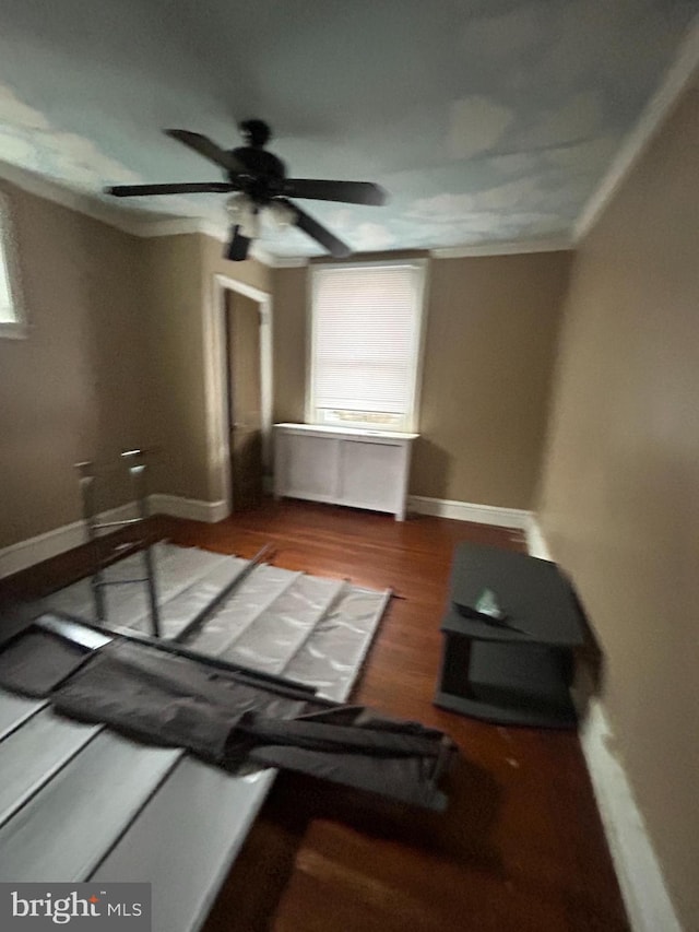 unfurnished living room featuring hardwood / wood-style floors, crown molding, and ceiling fan