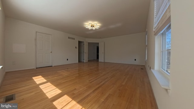 spare room with plenty of natural light, light wood-style flooring, and visible vents