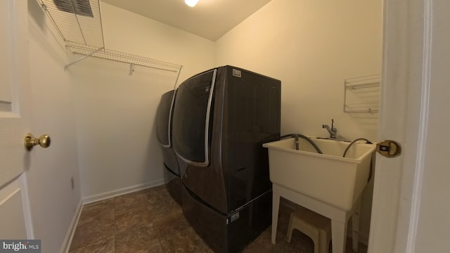 laundry room with laundry area, baseboards, and separate washer and dryer