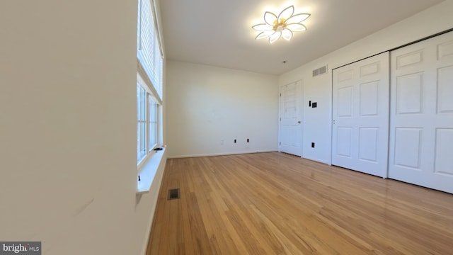 unfurnished bedroom with light wood-style flooring and visible vents