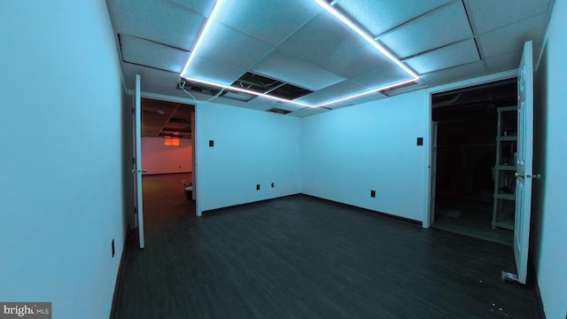 basement featuring dark wood-style flooring and baseboards