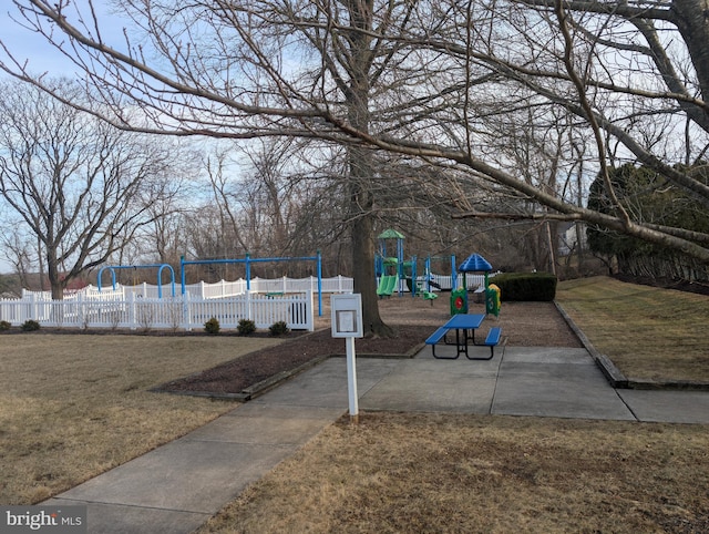 surrounding community with a lawn, fence, and playground community