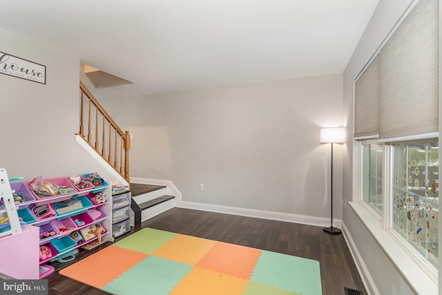 recreation room with dark wood-type flooring